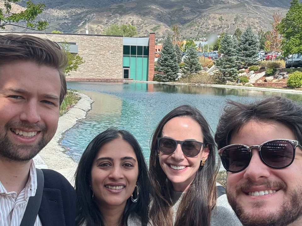 Four members of the Banquet team outside by a pond, with mountains behind them